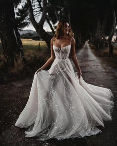 a woman in a white dress is walking down the road