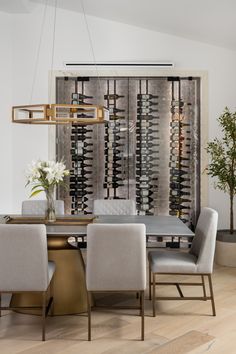 a dining room table with four chairs and a wine rack in the backround