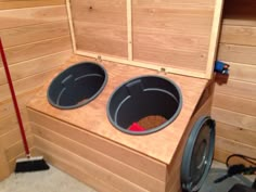 two buckets on top of a washer in a room with wood paneling