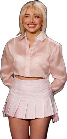 a woman with blonde hair wearing a pink shirt and skirt