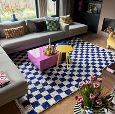 a living room filled with furniture and a colorful rug on top of a hard wood floor