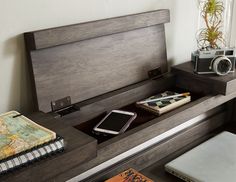 a desk with a phone, camera and books on it