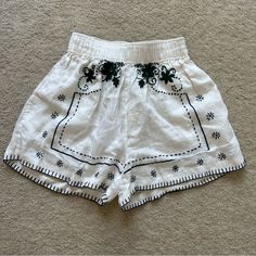 Romi Embroidered Shorts From All That Remains. White With Navy And Emerald Embroidery. Size Au6 With Elastic Stretch Waistband (Best Fits Xs). 100% Linen. Stitching On The Bottom Has Become Slightly Loose (Pictured) But Other Than That There Are No Flaws. Message For Questions! Chic Embroidered Summer Bottoms, Chic Embroidered Short Length Shorts, Chic White Bottoms With Floral Embroidery, Summer Cotton Bottoms With Embroidered Border, Traditional White Bottoms For Summer, Traditional White Summer Bottoms, Traditional Summer Bottoms With Embroidered Hem, Bohemian Floral Embroidered Shorts For Summer, Traditional Embroidered Bottoms For Summer