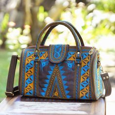 Named after the beautiful Banda region of Indonesia this handle handbag is designed by Balinese artisan Anita Jo. The black cotton handbag features beautiful saffron and teal hand embroidery that creates triangular swirl and zigzag patterns in the traditional style of the Banda Aceh province which was hit by a devastating tsunami in 2004. Opening with a zipper the handbag reveals a black lined interior complete with a zipper pocket on one side for storing small items. Top Handle Embroidered Satchel For Travel, Embroidered Top Handle Satchel For Travel, Brown Embroidered Rectangular Satchel, Embroidered Brown Rectangular Satchel, Embroidered Brown Tote Satchel, Brown Embroidered Tote Satchel, Brown Embroidered Satchel For Travel, Daily Use Brown Embroidered Satchel, Traditional Embroidered Top Handle Shoulder Bag