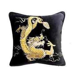 a black and gold dragon pillow on a white background