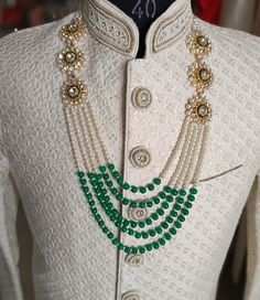 a white jacket with green beads on it