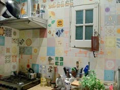 a kitchen with colorful tiles on the wall and counter tops, along with pots and pans