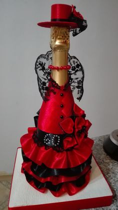 a red and black dress with angel wings on it's head is sitting on top of a table