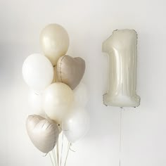 some balloons and a number one balloon on a wall