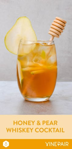 honey and pear whiskey cocktail in a glass with a wooden stick sticking out of it