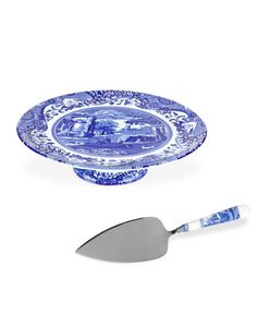 a blue and white plate with a spatula next to it on a white background