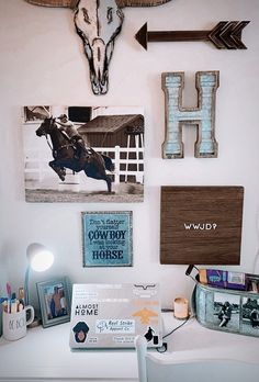 a white desk topped with lots of pictures and other items next to a wall mounted on the wall