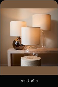 three lamps sitting on top of a wooden table