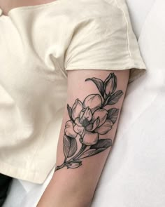 a woman's arm with a flower tattoo on the left side of her arm