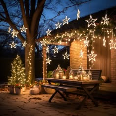 an outdoor patio decorated for christmas with lit stars and lanterns on the side of it