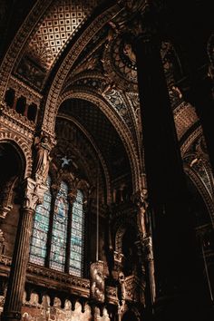 the inside of a church with stained glass windows and pillars in it's center