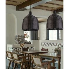 a dining room table with chairs and two hanging lights