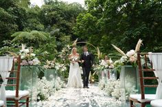 a bride and groom are walking down the aisle at their wedding in an outdoor ceremony