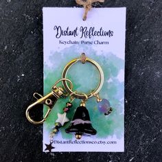 a keychain with a bell charm attached to it's front and back ends