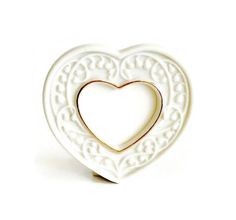 a white heart shaped brooch with gold accents