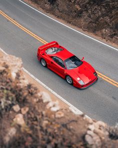 a red sports car driving down the road