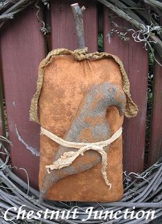 a stone bird sitting on top of a piece of wood in front of a wooden fence