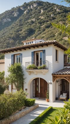 a white house with mountains in the background