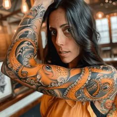 a woman with an octopus tattoo on her arm is posing in front of a mirror