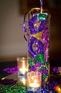 a vase filled with beads and candles on top of a table