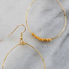 These big beaded hoops in gold or silver are the perfect simple statement — just right for those busy mornings when finding something that matches your outfit is just too much to ask. stainless steel ear wire and hand-shaped hoop with faceted beads choose gold-plated or silver-plated lead-free and nickel-free plastic earring back 2.5" long and 1.5" wide (each pair is handmade so sizes can vary slightly) packaged on a kraft earring card in a clear resealing bag Adjustable Gold Hoop Earrings With Faceted Beads, Everyday Jewelry With Faceted Beads In 14k Gold Filled, Small Hoop Jewelry With Faceted Beads For Gifts, Minimalist Faceted Beads Jewelry For Everyday, Everyday Gold Jewelry With Faceted Beads, Minimalist Everyday Jewelry With Faceted Beads, Nickel Free Hoop Beaded Earrings For Everyday, Adjustable Hoop Earrings With Gold Beads As Gift, Hoop Jewelry With Faceted Beads For Gifts