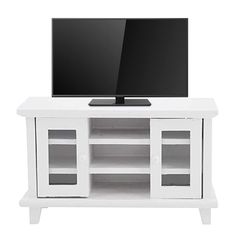 a flat screen tv sitting on top of a white entertainment center with shelves below it