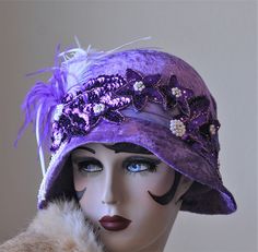 Women's cloche hat in a vintage 1920s Great Gatsby style.  A hat fancy enough for a wedding or any glitzy evening event.  The buckram hat is covered in a crushed purple velvet fabric that has been embellished with lots of sequins, pearls and feathers.    This hat is available in a SIZE MEDIUM (22 to 22 1/2")   How to measure your head.... Take a cloth measuring tape around the back of your head and over your ears. Have the tape meet on your forehead where you want the hat to sit. Do this several times as an accurate measurement is important.  Hats are 100% handmade using traditional tailoring techniques and the highest quality fabrics, hand sewn lining and details. FREE SHIPPINGby Priority mail is included.  Return shipping will be at buyers expense.  All refunds will be sent excluding the Gatsby Style Short Brim Costume Hats For Evening, Evening Gatsby Costume Hat With Short Brim, Gatsby Style Mini Hat With Short Brim For Evening, Winter Party Vintage Fascinator, Evening Gatsby Mini Hat With Short Brim, Fitted Flapper Cloche Hat, Winter Flapper Style Cloche Hat, Gatsby Style Party Cloche Hat With Short Brim, Flapper Style Fascinator For Kentucky Derby Evening