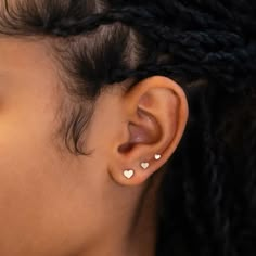 a close up of a person's ear with two small white hearts on it