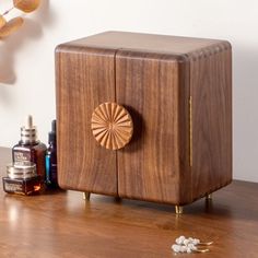 a wooden cabinet sitting on top of a table next to some bottles and other items