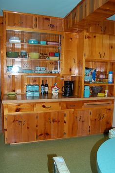 a kitchen with wooden cabinets and glass shelves