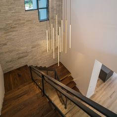 the stairs are made of wood and have metal rods hanging from them, along with glass windows