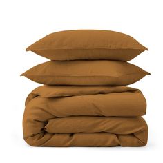 three pillows stacked on top of each other in front of a white background and the bottom one is brown