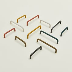 six different colored metal hooks on a white surface