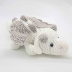 a crocheted stuffed animal laying on top of a white table next to it's head