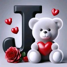 a white teddy bear holding a red heart sitting next to the letter j with hearts around it