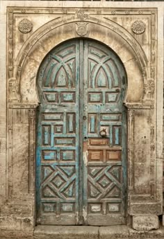 an old wooden door with intricate carvings on the front and side doors are painted blue