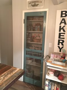 a kitchen with a wooden table and blue door