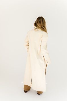 a fresh take on the oversized blazer, this cream trench coat is a must-have for business casual baddies. it has a relaxed longline silhouette, luxe working buttons, + is made with a thick cotton material (so it will actually keep you warm). the perfect spring // winter coat to elevate your casual fits or embellish your formal ones. natural // lapel collar, buttons, pockets, cuffed sleeves, corduroy paired with our charlotte wrap top + kenny cargo pants + hardi slingback penny loafers model is 5' Oversized Single Breasted Cream Outerwear, Oversized Cream Single-breasted Outerwear, Chic Cotton Outerwear With Hidden Button Closure, Cream Cotton Outerwear For Daywear, Winter White Cotton Outerwear For Work, Chic Oversized Long Coat Blazer, Oversized Beige Cotton Blazer, Cream Cotton Outerwear For Work, Chic Long Cotton Coat