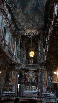 the interior of an old church with ornate paintings on the walls and ceiling, along with pews