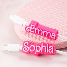 two pink personalized usb devices sitting next to each other on top of a white surface