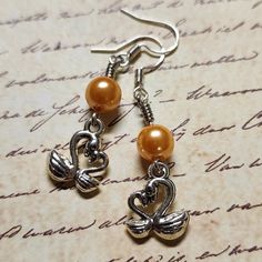 Swan Dangle Earrings with Orange Pearl.  Dangle approx 1.75".  Hypo-allergenic sterling silver ear wires. Nickel-free Silver Dangle Pearl Earrings, Silver Metal Drop Pearl Earrings, Hypoallergenic Metal Dangle Pearl Earrings, Hypoallergenic Dangle Pearl Earrings, Nickel-free Silver Drop Pearl Earrings, Gift Pearl Earrings With Metal Ear Wire, Sterling Silver Dangle Pearl Earrings With Ear Wire, Silver Drop Pearl Earrings With Ear Wire, Silver Metal Pearl Earrings As Gift