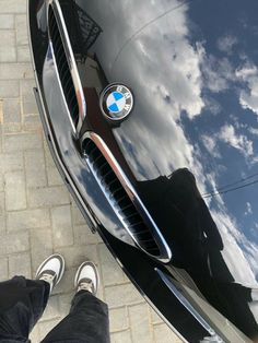 a person standing next to a bmw car