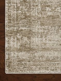 an area rug on top of a wooden floor with a brown and white color scheme