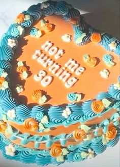 a blue and orange birthday cake with the words happy birthday on it's top