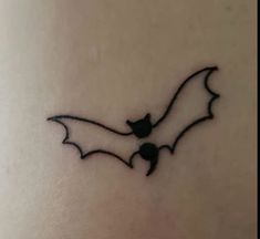 a bat tattoo on the back of a woman's stomach